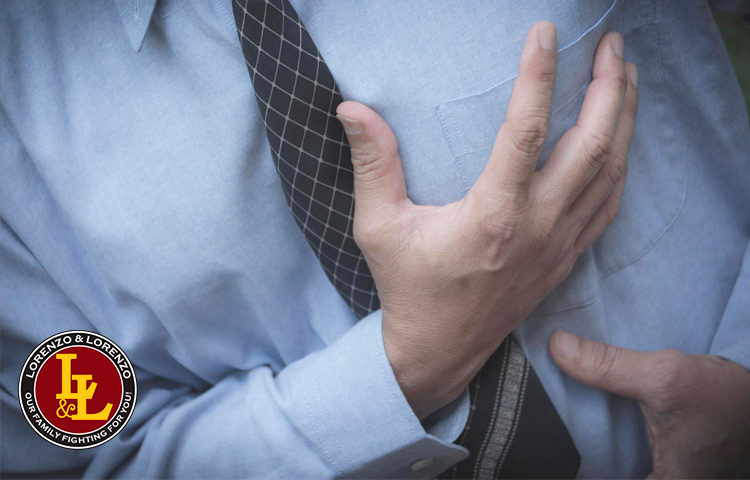 man having a heart attack clutches his chest