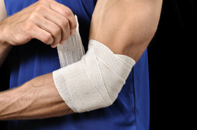 Man bandaging arm: Lorenzo & Lorenzo Personal Injury Blog